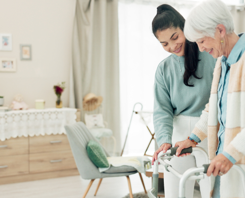 A carer supporting an older person while walking, part of dementia and falls prevention