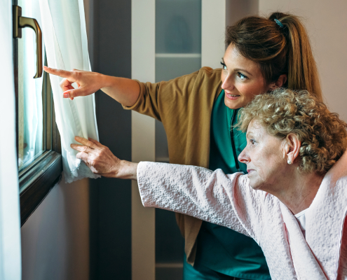 A trained carer providing dementia care training support to an elderly person at home in Lancashire