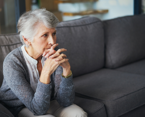 A carer providing support for elderly living at home, sitting with an older woman in her living room in Lancashire
