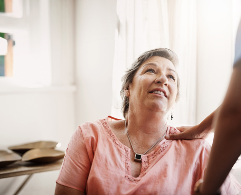 A family carer sitting with an elderly loved one at home, supporting understanding dementia for carers
